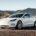 White Tesla Electric Car Cruising on the Road - Emblem of Modern Vehicle Innovation