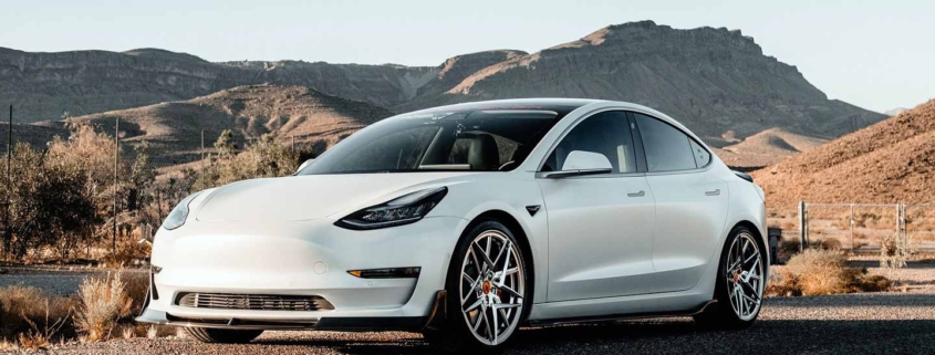 White Tesla Electric Car Cruising on the Road - Emblem of Modern Vehicle Innovation