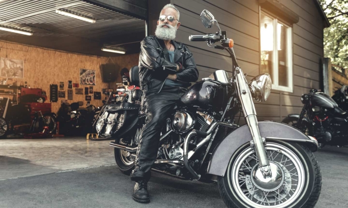 An elderly man confidently ready to ride his fixed and inspected salvage motorcycle purchased from RideSafely.