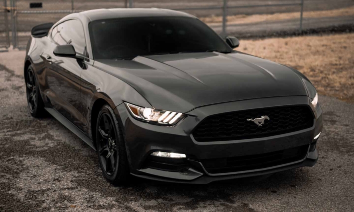 Buying a car at an online auction . A Black Ford Mustang Parked on the Street
