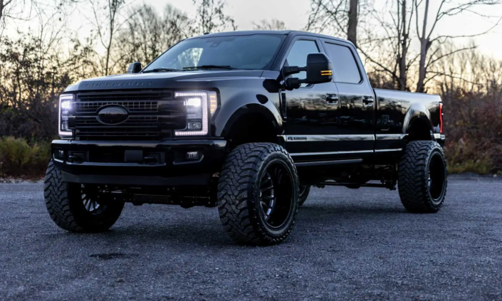 Lifted 2017 Ford F350 Platinum pick-up truck surrounded by woods, purchased at Car Auction RideSafely