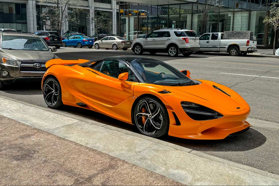 2024 Orange McLaren 750S sports car in downtown Calgary, showcasing its sleek design and high-performance engineering.