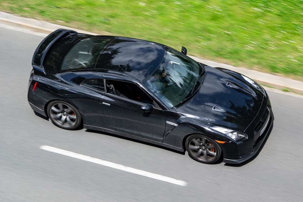 Black Nissan GT-R super sports car in motion, captured with a dynamic motion blur effect.