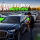 Best Time to Buy Cars at Auction - Save More With Better Timing. Professional buyer reviewing auction inventory while comparing seasonal vehicle buying opportunities at a large auto auction facility.